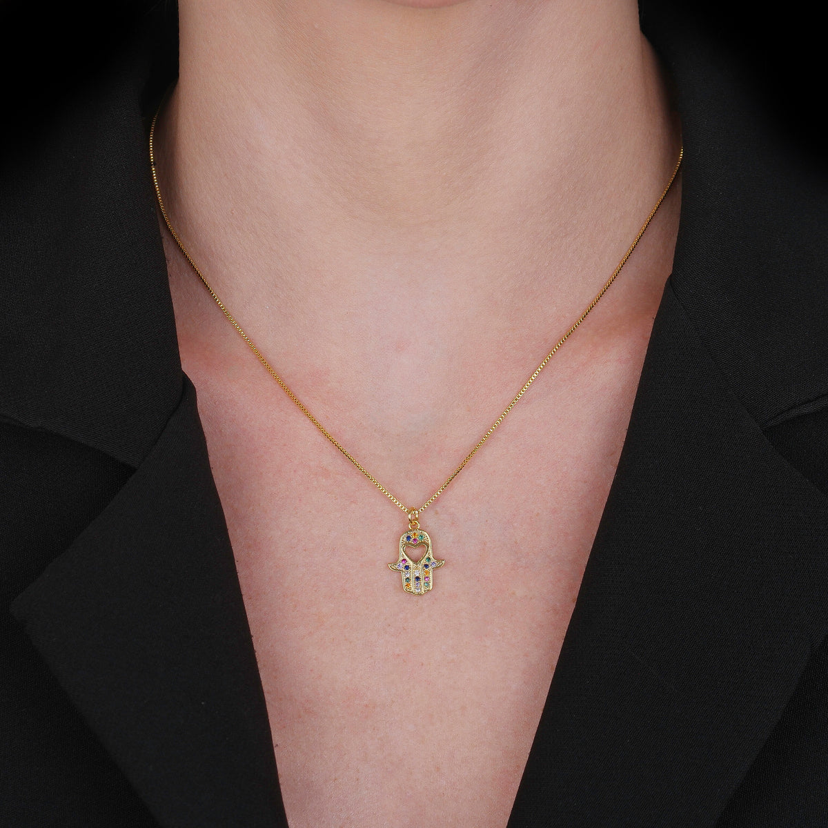 Colar Lilith Allure Dourado Mão de Fátima Cravejado de Zircônia Coloridas com Coração. Lilith Allure Gold Necklace – Hamsa Hand with Colorful Zirconia and Heart Charm