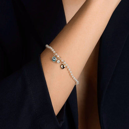 Pulseira Lilith Allure Dourada de Pérolas com Olho Grego Coração e Ponto de Luz / Lilith Allure Gold-Plated Pearl Bracelet featuring Evil Eye Charm, Heart Detail, and Sparkling Accent